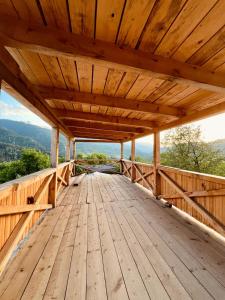 a wooden deck with awning on a mountain at Lakhushdi - House of Song in Mestia