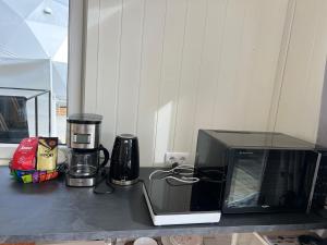 a counter top with a microwave and a blender at Evenes Artic glamping in Evenesmarkja +13 photos