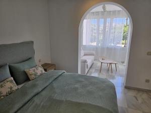 a bedroom with a large bed and an arched window at villa bahía banus in Marbella +39 photos