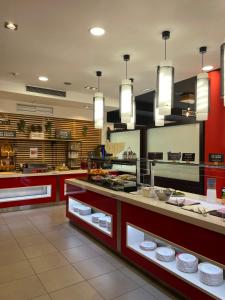 a restaurant with a counter with plates on it at Ibis Budget Girona Costa Brava in Girona