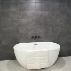 a large white bath tub in a bathroom at Tropical Kuranda Modern Retreat in Kuranda