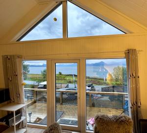 a room with a large window with a view of the ocean at Evenes Artic glamping in Evenesmarkja