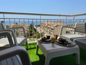 a table with two plates of food and drinks on a balcony at Sea views from the bed Design studio in Torrox