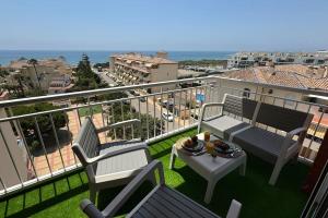 a balcony with two chairs and a table with food on it at Sea views from the bed Design studio in Torrox