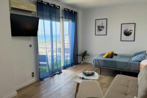a living room with a bed and a large window at Sea views from the bed Design studio in Torrox