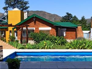 a house with a swimming pool in front of a house at La Estrella 2 in Huerta Grande