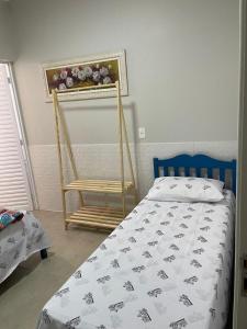 a bedroom with a bed and a wooden chair at Pousadinha Dinos tour e cia in Uberaba +9 photos