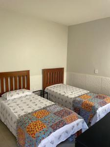 two beds in a room with two beds sidx sidx sidx at Pousadinha Dinos tour e cia in Uberaba