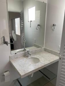 a bathroom with a sink and a mirror at Pousadinha Dinos tour e cia in Uberaba