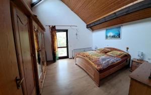 a bedroom with a large bed and a wooden ceiling at Ferienwohnung Heckenäcker in Ortenberg