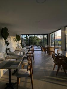a restaurant with wooden tables and chairs and windows at Casa Mora Zeytinli in Edremit