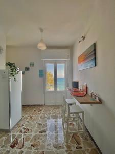 a kitchen with a table and a desk with a laptop at Acquamarina B&B Deluxe in Cariati
