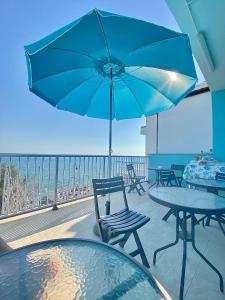 a patio with tables and chairs and an umbrella at Acquamarina B&B Deluxe in Cariati +36 photos