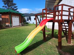 a playground with a slide in a yard at La Estrella 3 in Huerta Grande