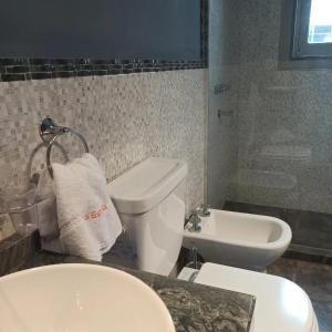 a bathroom with a toilet and a sink at La Estrella 3 in Huerta Grande +10 photos