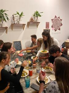 a group of people sitting around a table eating food at Tamaran House in Las Palmas de Gran Canaria