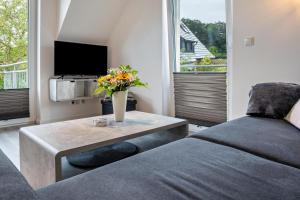 a living room with a bed and a table with flowers at Ostseerauschen in Hohwacht