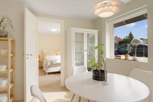 una sala da pranzo bianca con tavolo e una camera da letto di New and Urban Apartment, centrally located close to nature a Haugesund