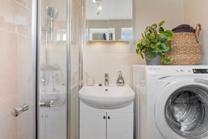 un bagno con lavatrice e lavandino di New and Urban Apartment, centrally located close to nature a Haugesund