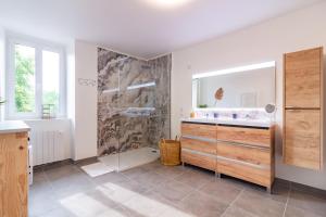 a bathroom with a shower and a sink and a mirror at Le Gîte de la Route 999 - Belle maison de campagne in Montlaur