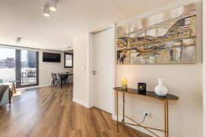 een woonkamer met een tafel en een schilderij aan de muur bij Aspasios Bonjardim Apartments in Porto