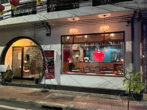 a store window of a store with a red sign in it at Caiyong Hometel & Cafe's Studio in Khlong San +38 photos