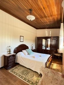 una camera da letto con un letto grande e un soffitto in legno di Casa do Conde Praia da Barra a Gafanha da Nazaré