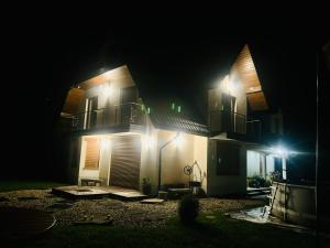 a house lit up at night with lights at PRZY POTOKU -noclegi in Białka Tatrzańska