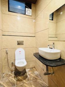 a bathroom with a sink and a toilet at Hotel Shreegopal in Ujjain