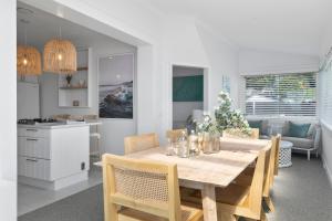 a dining room and kitchen with a table and chairs at Luxury Manly Oceanfront Getaway in Sydney +14 photos