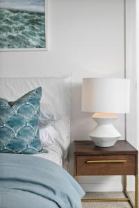 a bed with a lamp on a night stand next to a bed at Luxury Manly Oceanfront Getaway in Sydney