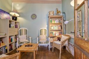 a room with two chairs and a table and bookshelves at Gîte de groupe Val dOrey in Ruffieu