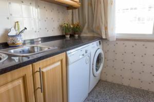 a kitchen with a sink and a washing machine at Carcavelos - Holiday Beach Apartment in Carcavelos