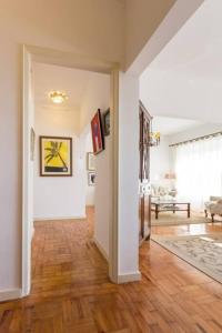 a living room with white walls and a wooden floor at Carcavelos - Holiday Beach Apartment in Carcavelos