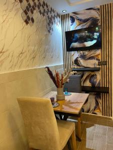 a dining room with a table and a television at Studio Jouri in Rabat