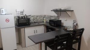 a small kitchen with a sink and a microwave at Shalom Self Catering in Lüderitz