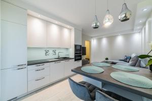 a kitchen and dining room with a table and chairs at Amber Apartments in Šiauliai