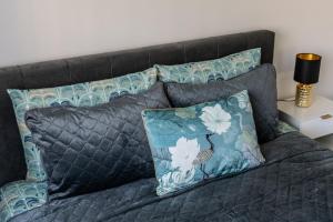 a bed with two pillows and a gray blanket at Amber Apartments in Šiauliai