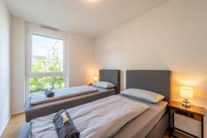 a bedroom with two beds and a window at EXQUIS 2BR Luxus Apartment TAO I Parken I Netflix I Garten I Familienfreundlich I in Holzgerlingen