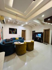 a living room with two blue couches and a tv at PP with rooftop pool and bathtub in Lonavala +27 photos