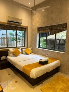a bedroom with a large bed with yellow pillows at PP with rooftop pool and bathtub in Lonavala