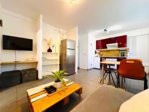 a living room with a table and a kitchen at Appartement Les Trois Renards-Tassin in Tassin-la-Demi-Lune
