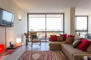 a living room with a couch and a tv at Cascais Panoramic Apartment in Cascais