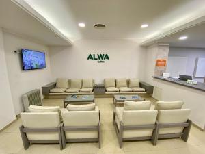 a waiting room with couches and a table and chairs at ALWA Suites in Resistencia