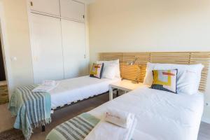 a room with two beds and a table in it at Cascais Panoramic Apartment in Cascais +19 photos