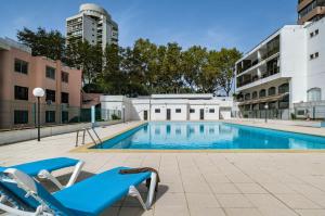 a swimming pool with two lounge chairs next to a building at Cascais Panoramic Apartment in Cascais
