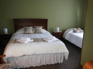 1 dormitorio con 2 camas y toallas. en VALYAK rent apart hotel - Servicios Integrales, en Punta Arenas