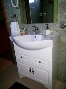 lavabo blanco en el baño con espejo en VALYAK rent apart hotel - Servicios Integrales en Punta Arenas