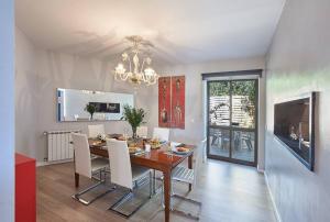 a dining room with a table and white chairs at Central Holiday Home in Cascais