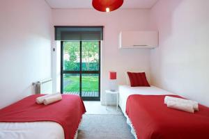 a room with two beds with red and white sheets at Central Holiday Home in Cascais +35 photos